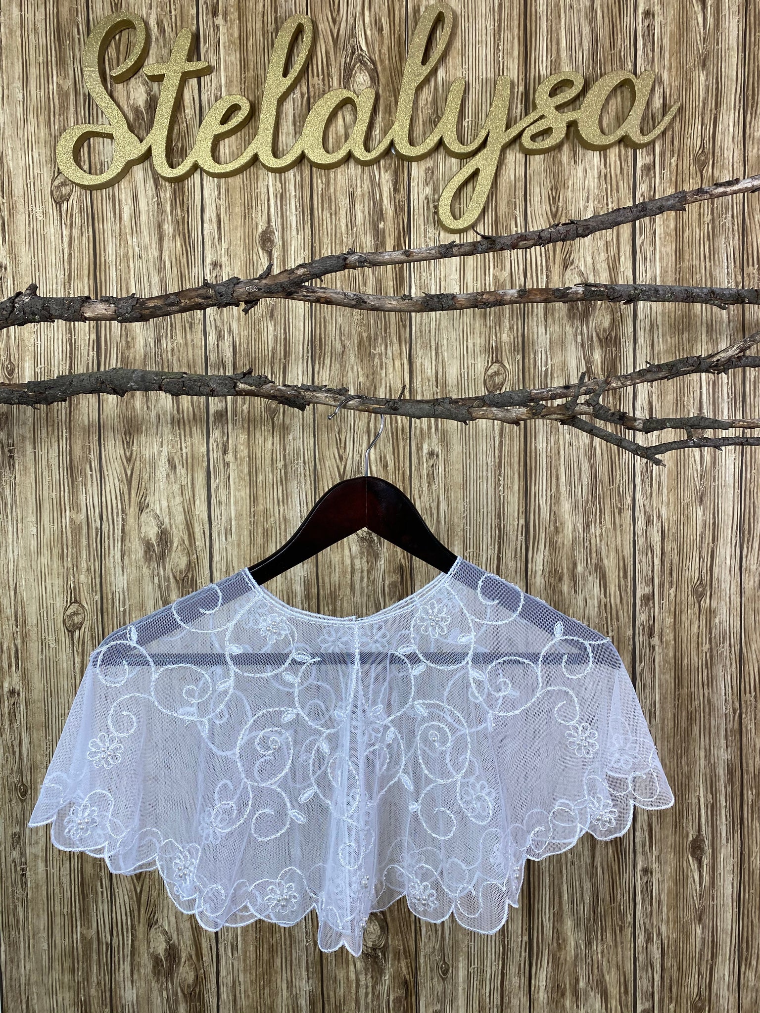Gorgeous tulle shawl with embroidered flower detailing throughout body, showcasing beautiful pearls in the center.  This shawl can be worn with either a white or ivory communion dress/gown from our collection.  She will look like a princess wearing this elegant shawl on her special day!  