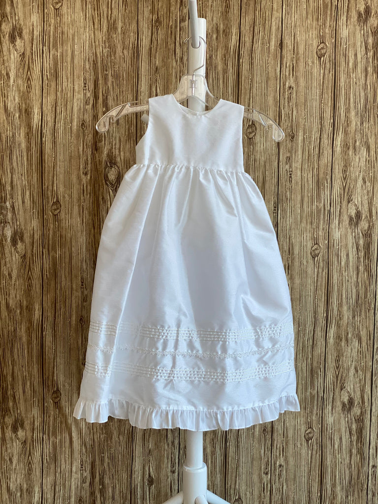 This a beautiful, one-of-a-kind baptism gown.  A lovely gown for a precious child.  White, size 6M Silk bodice with pleated square effect Pearls throughout bodice Two piece silk skirting Pleated square detailing on skirt with pearls throughout Ribboned pinstripes on skirting Ruffled trip along skirt edge Ruffled sleeves Button closure Matching bonnet