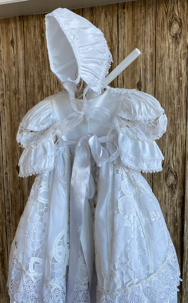 This a beautiful, one-of-a-kind baptism gown.  A lovely gown for a precious child.  White, size 6M Satin bodice with satin collar Beautiful lace trim edging collar and sleeves Gorgeous ribbon flower placed on bodice edge Satin puff sleeve with lace patch  Satin skirting with lace overlay  Thick embroidered lace ribboning around overlay and skirt edge Lovely satin bonnet with thick embroidered lace brim Mesh ribbon closure on bonnet