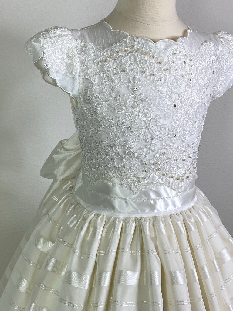 Ivory, size 8 Embroidered ivory scalloped cap sleeve Ivory scalloped scoop neck Jeweled Embroidered ivory satin bodice Wide ivory satin ribbon cummerbund Ivory horizontal striped tulle skirt Button closure Ivory satin ribbon for large bow