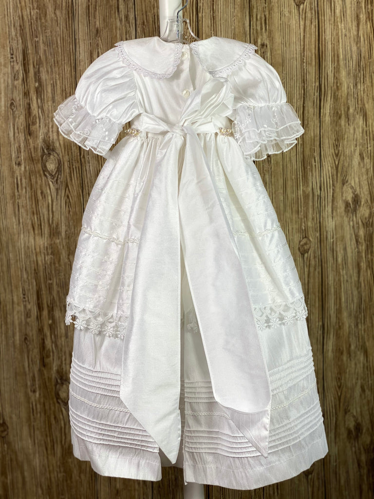 This a beautiful, one-of-a-kind baptism gown.  A lovely gown for a precious child.  White, size 12M Two layer dress Satin bodice with lace overlay Satin collar with lace trim Rhinestone pearl belting Puffed satin sleeves with lace trim Horizonal pinstripes with lace trim Second layer has horizonal pinstripes with lace trim  Satin bow in back Satin bonnet with ruffled lace brim