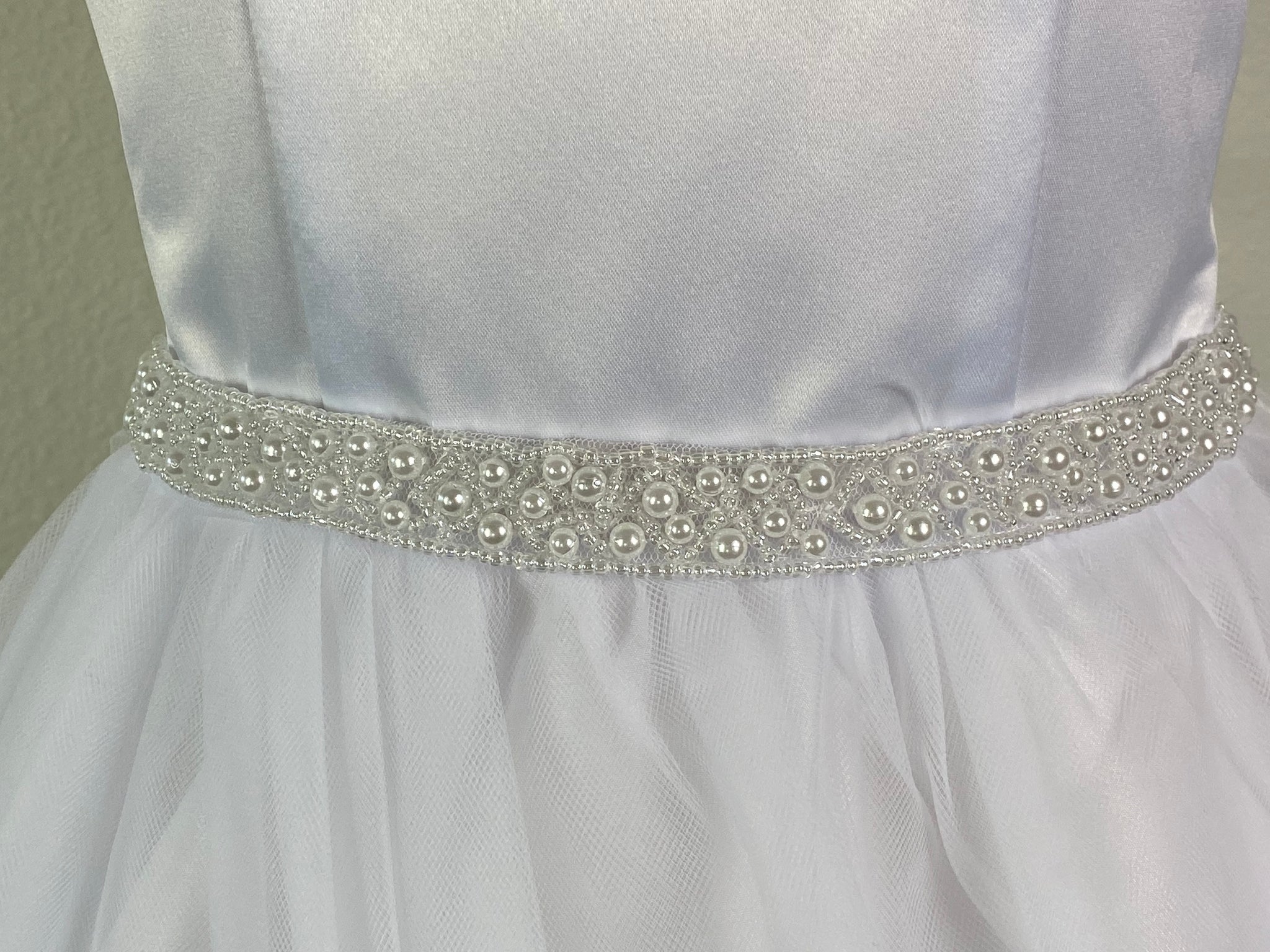 White, size 10 Pearl cap sleeve Satin paneled bodice Thin beaded belt Satin skirt with tulle overlay Zipper closure Satin ribbon for bow