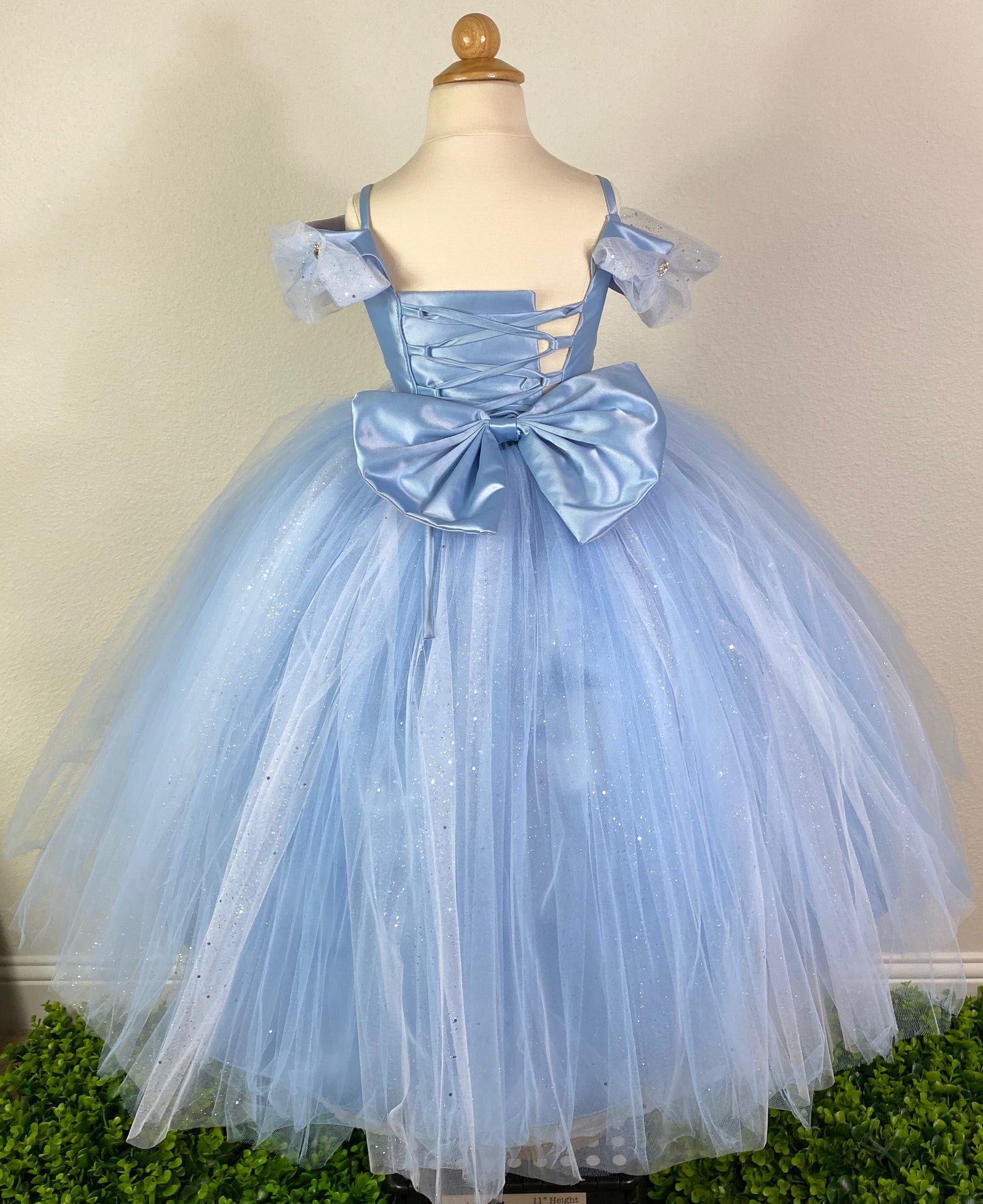 This beautiful dress comes in two colors- Yellow & Blue Satin bodice  Off the shoulder sleeve Sparkle tulle wrapping around bodice and sleeves Rhinestones placed throughout tulle Swirled rhinestone belting Large tulle skirting with peak-a-boo sparkle tulle Coreset style back Large bow on back Dress pictured with a petticoat Petticoat not included  Choose from a tulle, cloth, or wire for best look
