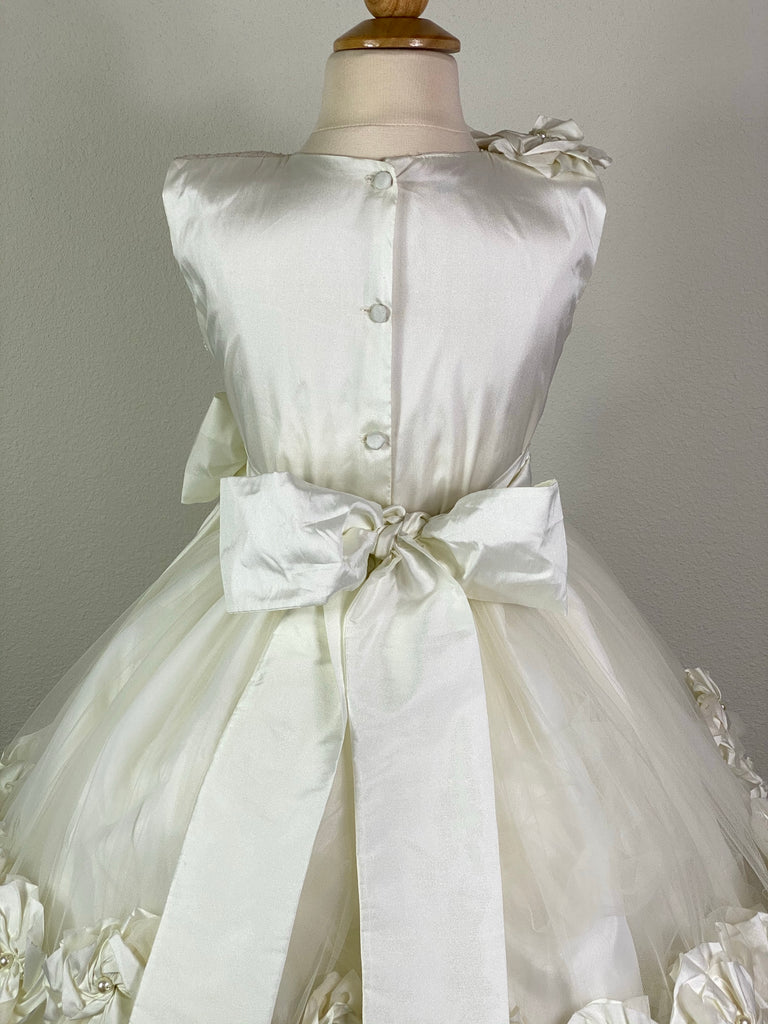 Ivory, size 10 Embroidered pinstripe bodice with ivory satin flowers on shoulder Large bow with pearl center on ivory ruched cummerbund Layered tulle skirt with large pinwheel flowers and braided stripes along edge Satin covered button closure Ivory ribbon for large bow
