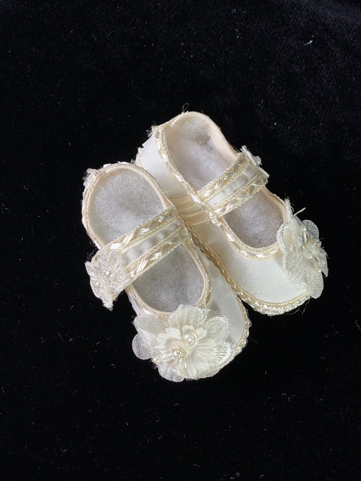 Elegant handmade ivory baby girl shoes with embroidery, lace, flowers, and pearls.