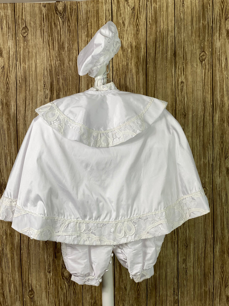 White, size 12M 3-piece set including romper, cape, beret Collared shirt with long sleeves Button closure on cape Wide embroidered lace edging on beret edge, cape and collar edges, and romper cuffs Pin striping on top romper bodice Elastic banding on back of pants Button closure on front of shirt and inside seam of legs