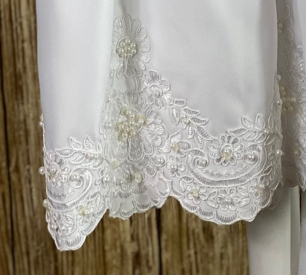 This a beautiful, one-of-a-kind baptism gown.  A lovely gown for a precious child.  White, size 12M Satin bodice with flower detailing on shoulder Satin ruffled cap sleeve Beaded belting Satin pleated skirting with handsewn lace detailing around bottom Zipper closure Satin bow in back