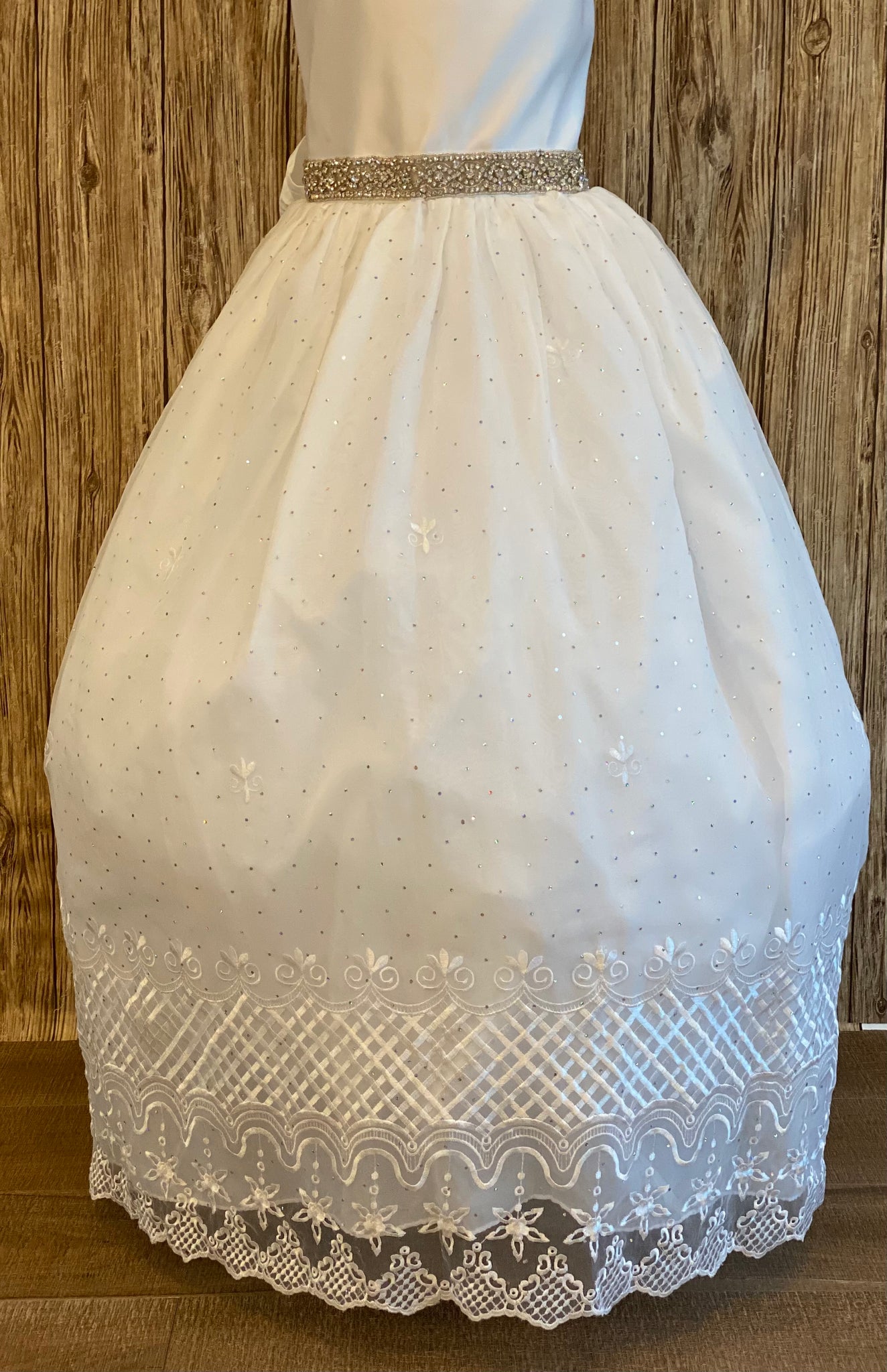 White, size 12 Scoop neck satin bodice Rhinestone belt Tulle skirt with jeweled detailing Embroidered lace trim among skirt edge Pearl buttoned closure Satin ribbon for big bow