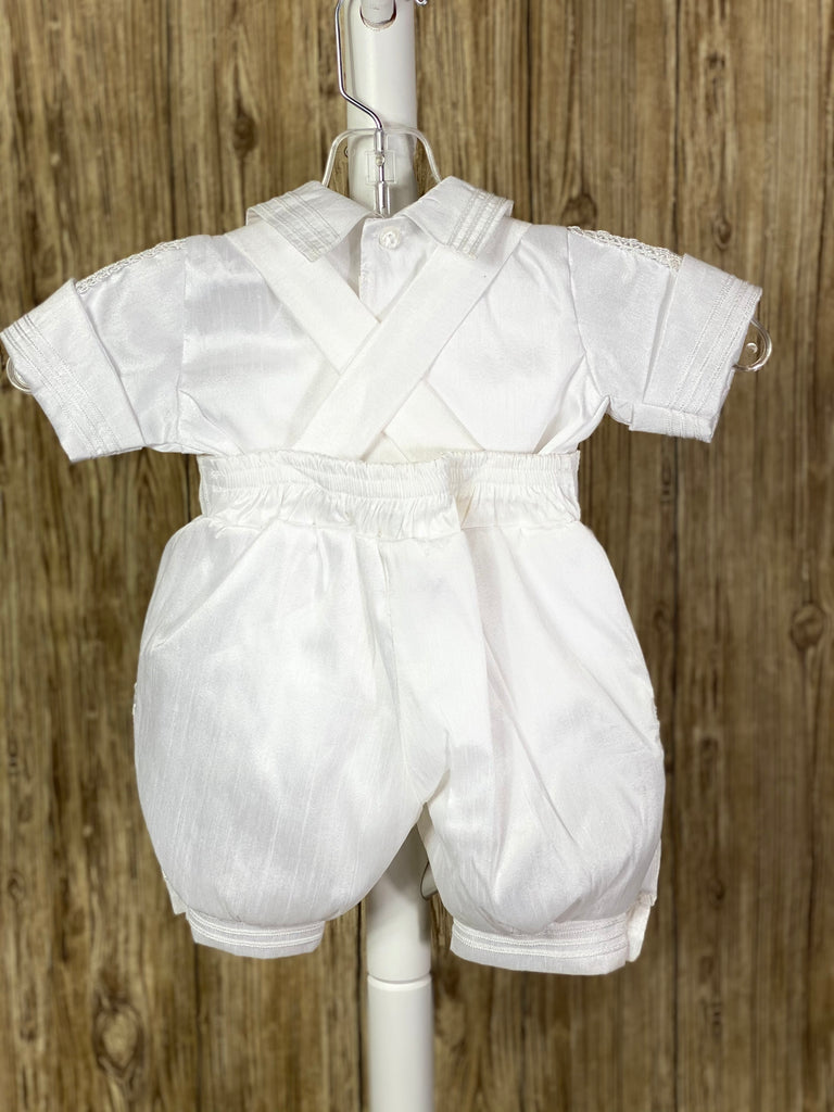 White, size 6M  4-piece set including Shirt, pants, stole, beret Collared shirt with short sleeves Buttoning on pant cuffs Elastic banding behind pants Button closure on back of shirt Thin trim striping pant legs, arm cuffs, stole, and cummerbund Crochet crosses on both sides of stole with rhinestone detailing Intricate lace ribbon down both sides of stole, beret, shirt bodice, and arms. Braided ribbon for stole closure