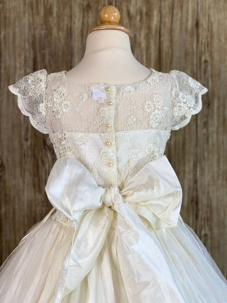 Ivory, size 10 Scalloped cap sleeve Ivory embroidered lace along illusion bodice and sleeve Elegant rhinestone band along lower bodice Gathered tulle skirt Corset closures on right and left underarms Ivory pearl button closure Ivory satin ribbon for large bow
