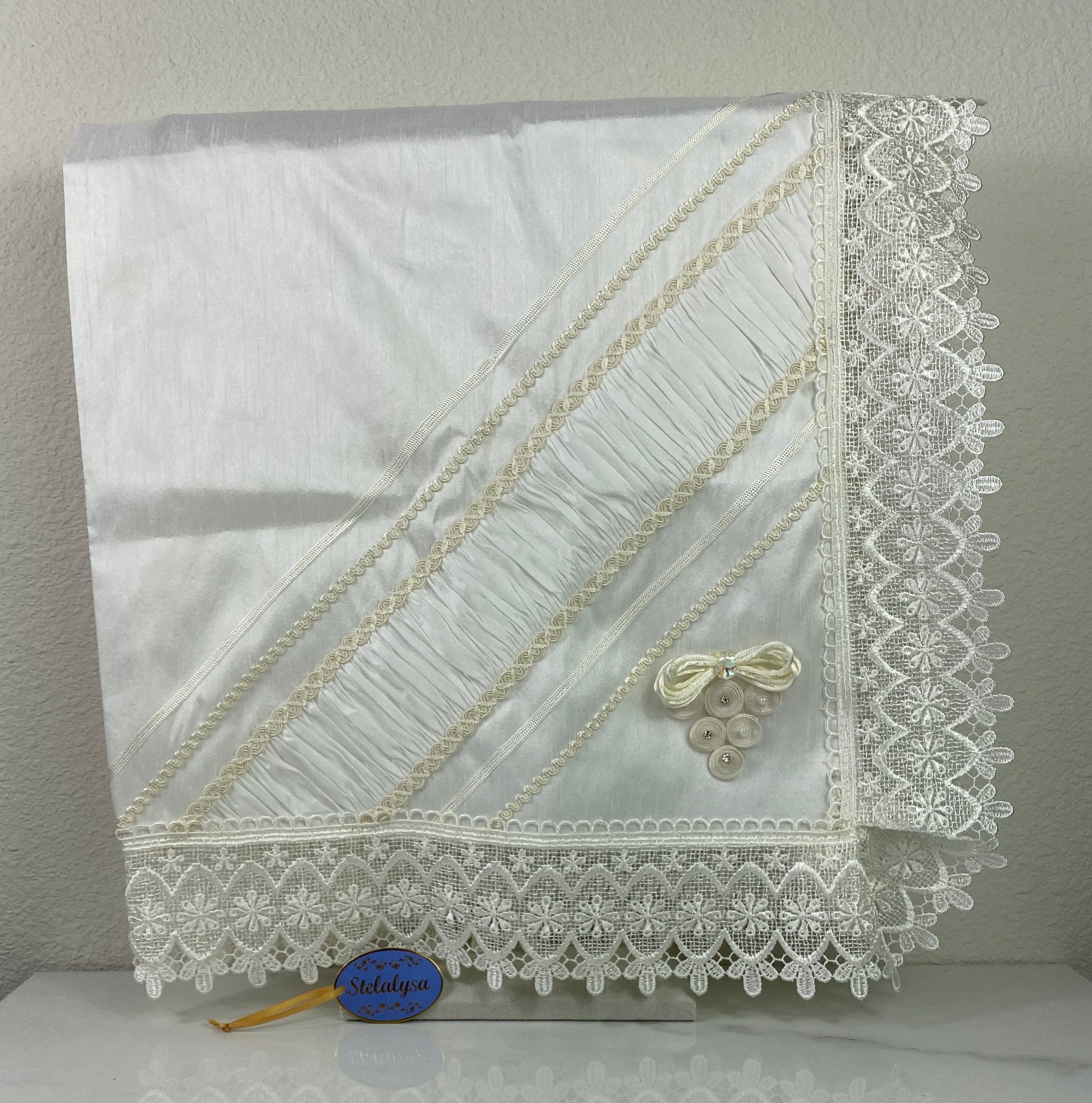 Beautiful embroidered  ivory silk baptism blanket with an bow, cross, elegant lace edge, and jewels.