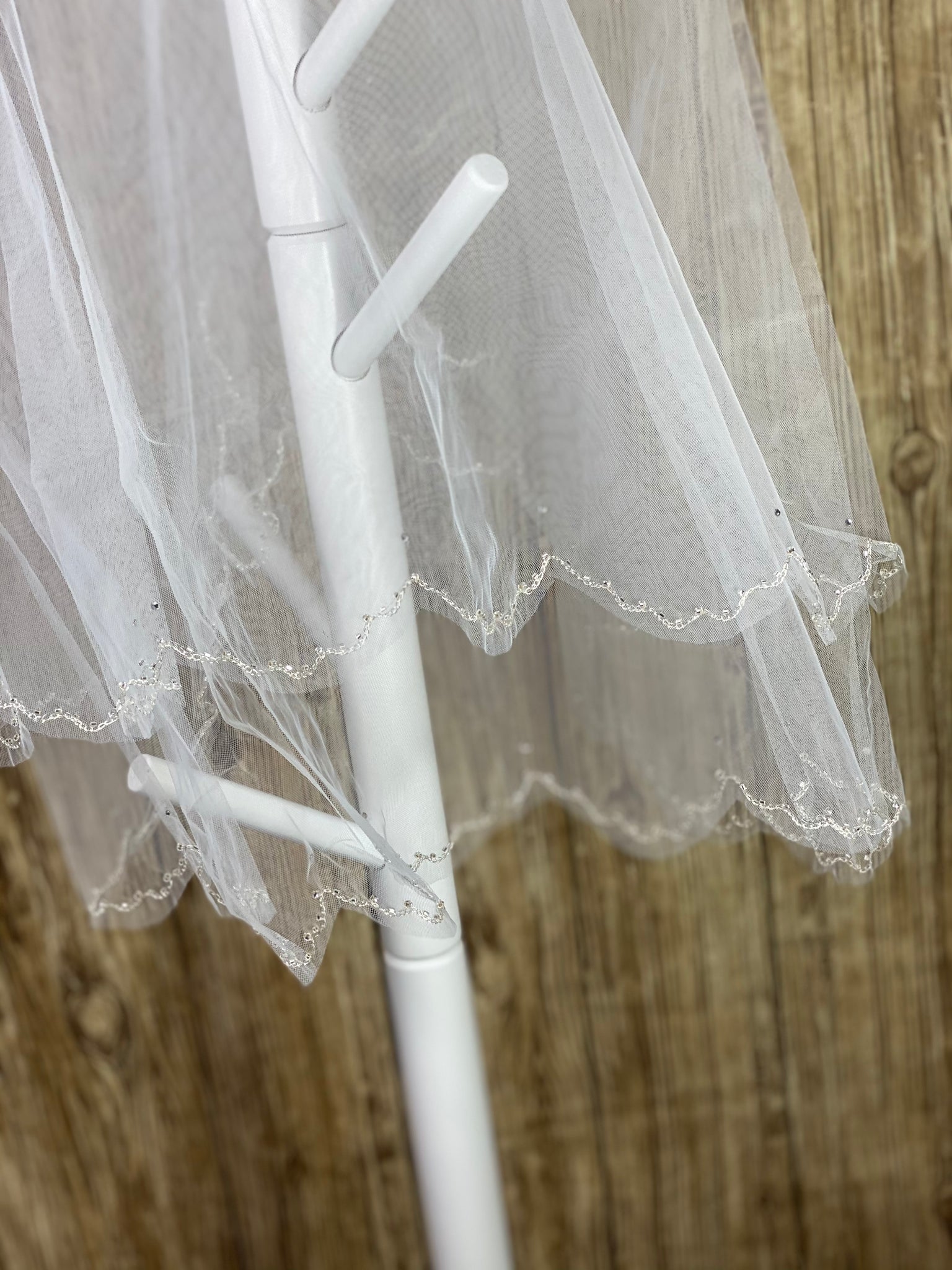 White - Scallop Jewel Veil for First Communion   Elegant soft 2 layer tulle veil with delicate hand stitched beads and scattered sequins.  Veil length - 29 in. long, comb - 11.5 cm wide  Materials:  sturdy plastic comb, soft tulle, and appliques - beads and sequins.