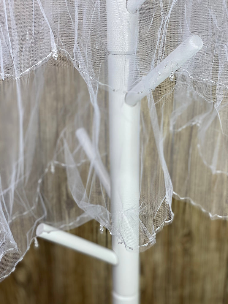 White - Pearl Drop Veil for First Communion   Elegant soft 2 layer veil with delicate white pencil trim, beads, and pearls.   Veil length - 26 in. long, comb - 7 cm wide  Materials:  sturdy plastic comb, soft tulle, and appliques - pearls and beads.