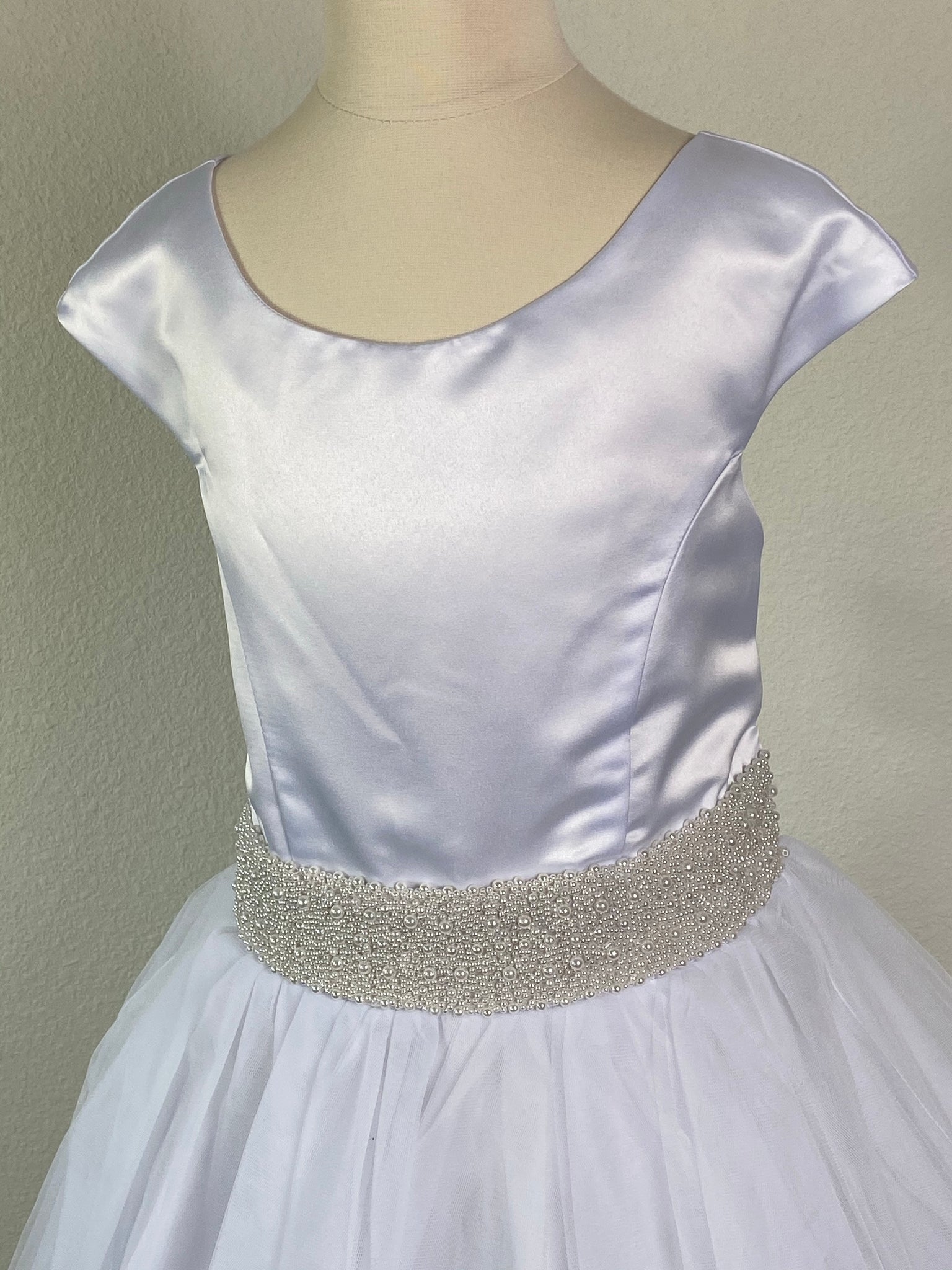 White, size 10 Satin bodice Wide pearl belt Tulle overlay with embroidered detailing Satin trim along skirt Zipper closure Satin Ribbon for bow