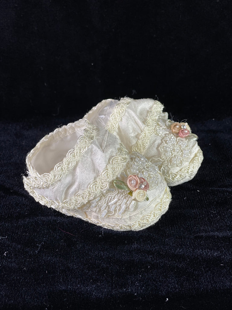 Elegant handmade white baby girl shoes with embroidery, lace, flowers, and jewels and Velcro closure.