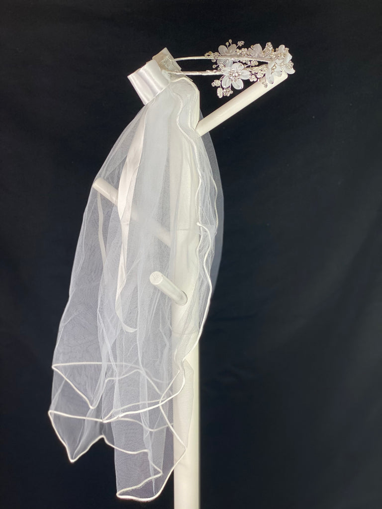 Elegant soft 2 layer tulle veil with delicate hand stitched braided satin trim around the edge and handmade flower halo crown with veil with large white satin bow on back. Organza flowers with sparkling rhinestone petals and centers. Beautiful clear beaded and pearl leaves sticking out around flowers.  This double layered veil reaches approximately 24" long, with a crown diameter of 6". Veil has 2" long, 3" wide, comb to secure it in place. 