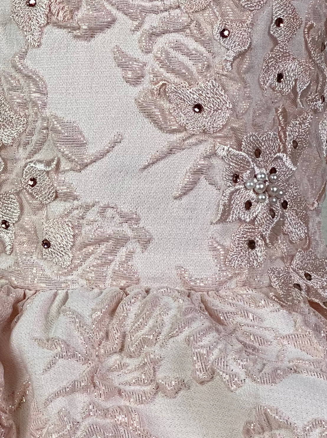 Blush, size 6 Embossed blush illusion bodice Embroidered jeweled lace detailing over bodice Embossed layered blush skirting Zipper closure Blush ribbon for bow in back Dress pictured with a petticoat Petticoat not included  Choose from a tulle, cloth, or wire for best look