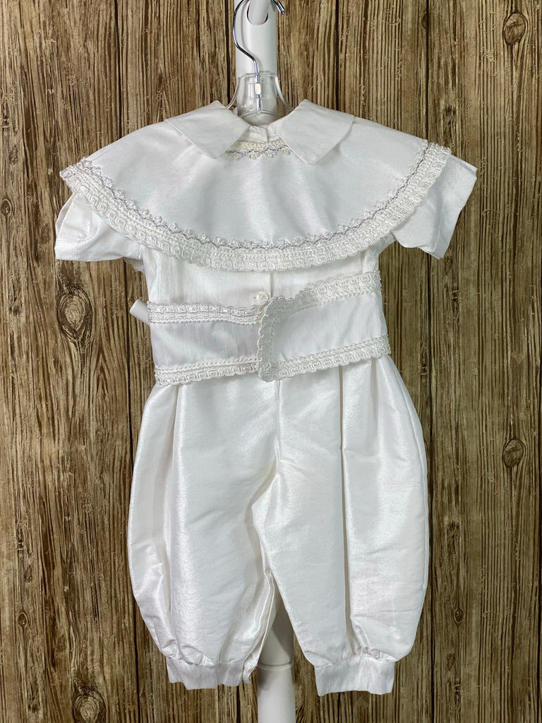 WHITE   4-piece white set including romper, belt, beret and mozzetta Collared with short sleeve Intricate braided trim lining belt and mozzetta edges Thin trim lining cuffs, beret, and bodice Button closure on back Rope closure on mozzetta