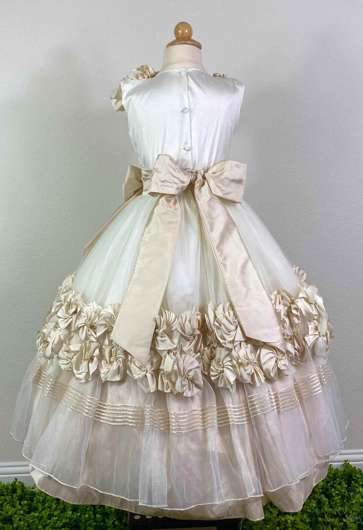 Ivory, size 8 Embroidered ivory pinstripe bodice with large pearled beige flowers on shoulder Beige cummerbund with pearl detailing on large bow Layered ivory tulle skirt with flower detailing on trim of first layer Six stacked braided stripes along edge of second tulle layer Satin covered button closure Beige Satin Ribbon for large bow
