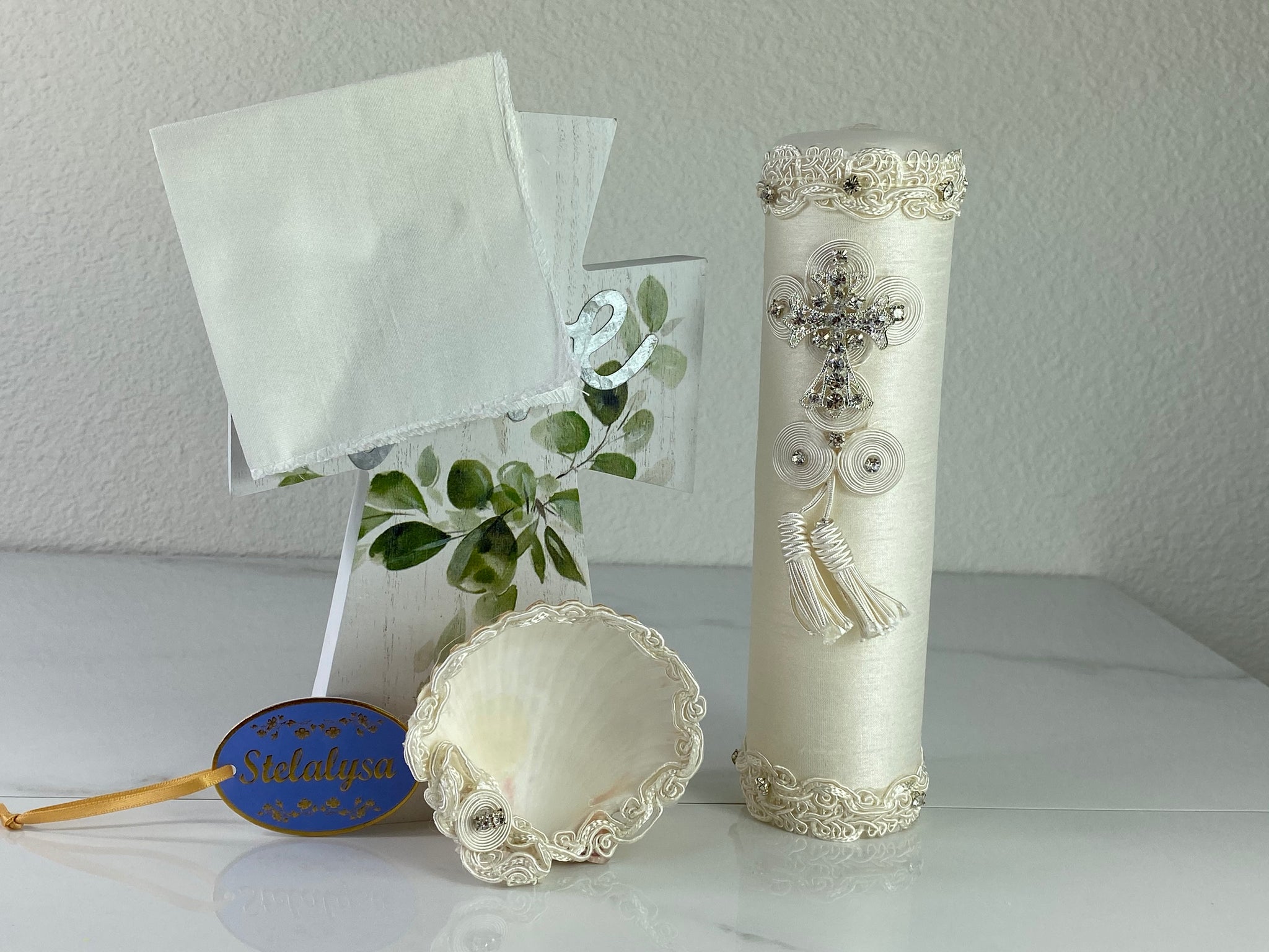 These one-of-a-kind Candle set is handmade and ivory in color.  This candle has a classic look.   It is uniquely decorated with crystals, lace, cross, and tassels making it a gorgeous keepsake.   This candle is cylinder in shape and matches many outfits from the Boys' Baptism Collection.    To match, the Shell is put together piece by piece to compliment the Candle and Handkerchief.  The Handkerchief is made of satin and embroidered lace to match the Shell and Candle beautifully.  
