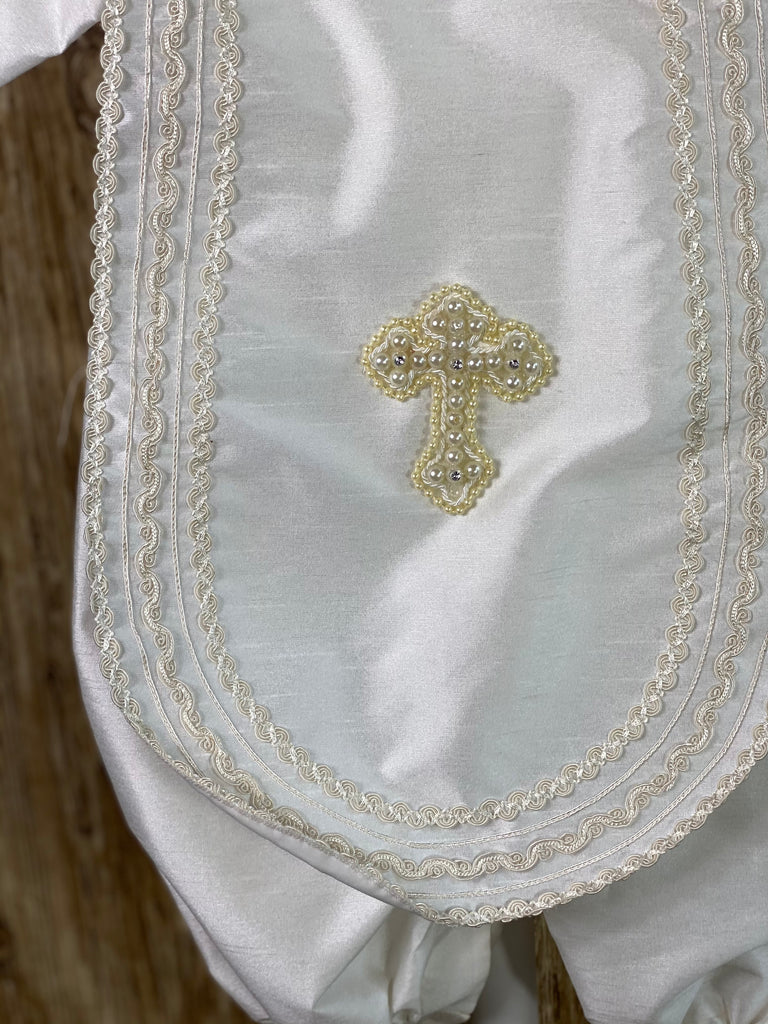 IVORY (pictures shown first)  3-piece ivory set including beret, one piece stole, romper Collared shirt with long sleeves Buttoning on pant cuffs Button closure on back of romper Wide embroidered trim along edge of stole and collar Thin embroidered trim along sleeve cuff edge Large pearl beaded cross on front of stole