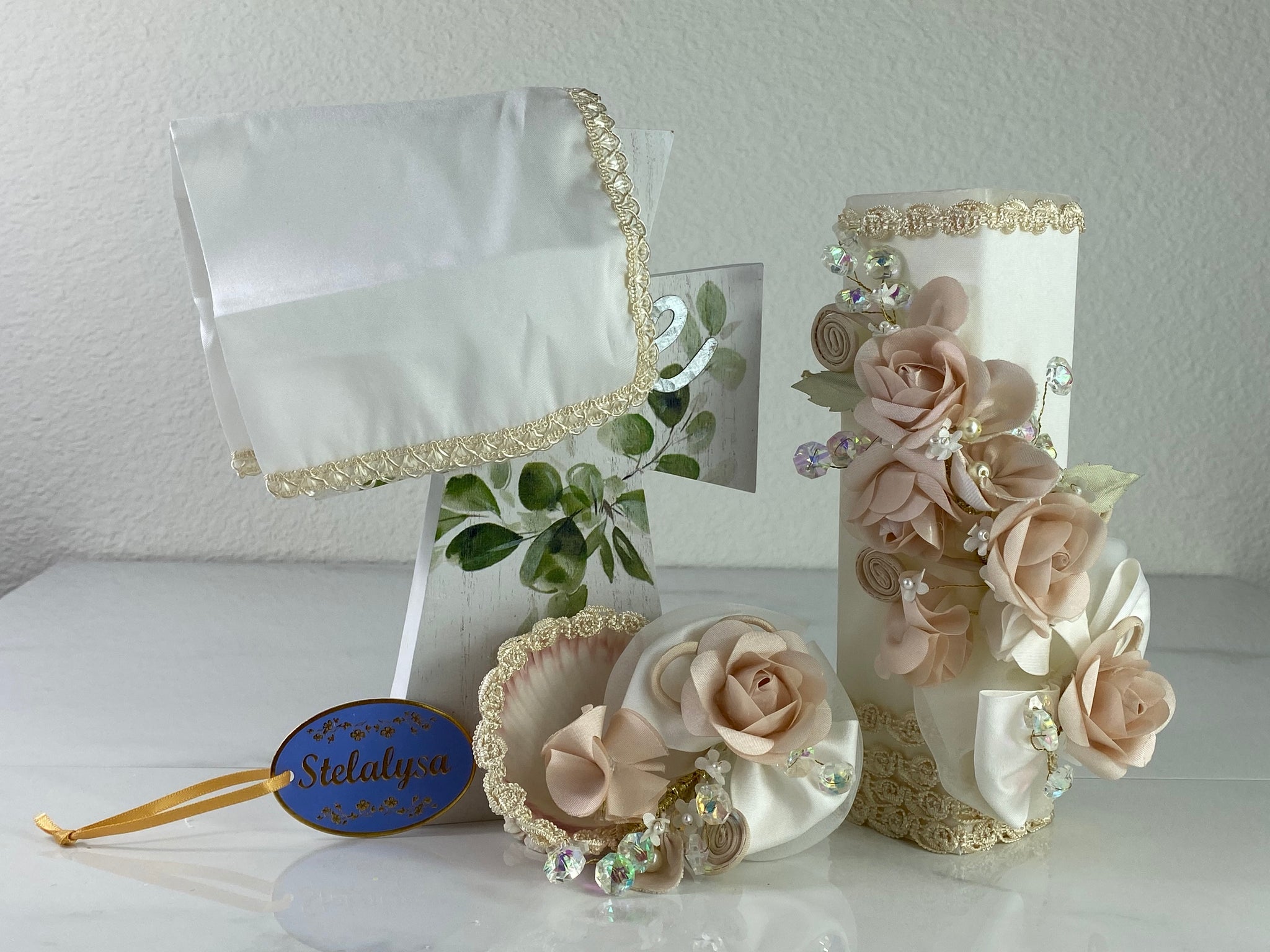 These one-of-a-kind Candle set is handmade and ivory in color.  This candle can also be use with a white baptism outfit because it has an array of light colors including white.   It is uniquely decorated with ribbon, pearls, crystals, flowers, and beads making it a gorgeous keepsake.   This candle is rectangular in shape.    To match, the Shell is put together piece by piece to compliment the Candle and Handkerchief.  