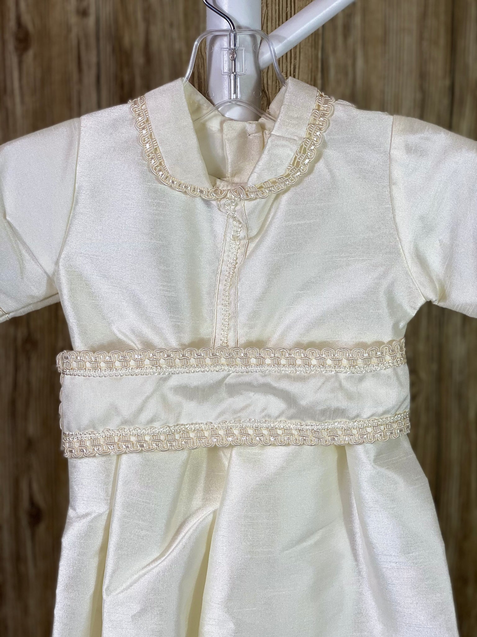 IVORY  4-piece ivory set including romper, belt, beret and mozzetta Collared with short sleeve Intricate braided trim lining belt and mozzetta edges Thin trim lining cuffs, beret, and bodice Button closure on back Rope closure on mozzetta